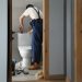 man fixing a toilet in a bathroom