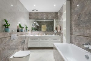 bathroom featuring a modern toilet, bathtub, and vanity