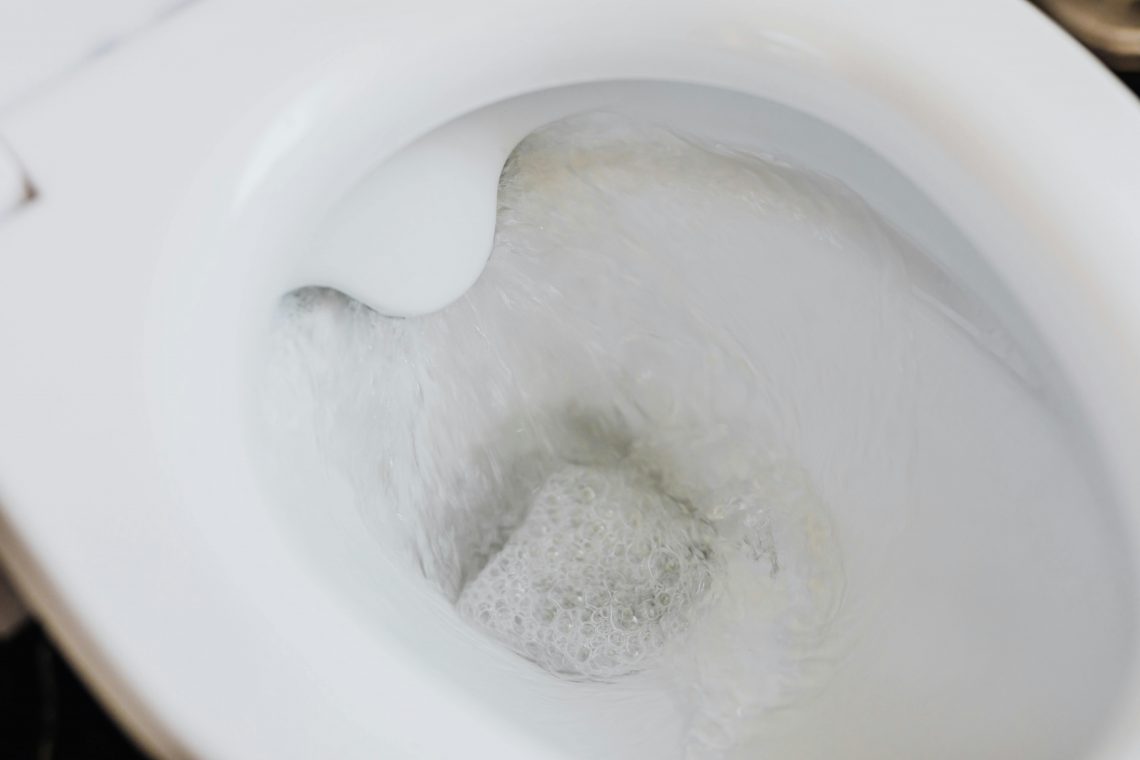close-up of a toilet with water running in the bowl