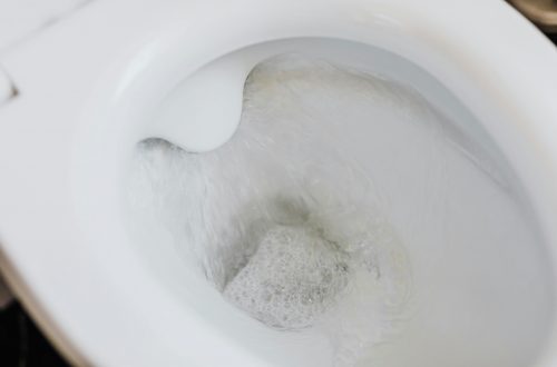 close-up of a toilet with water running in the bowl